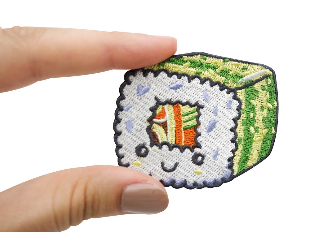 Hand hält grün-weißen Kawaii Sushi Patch
