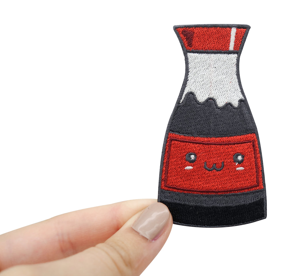 Hand hält Kawaii Soja Soße Patch.