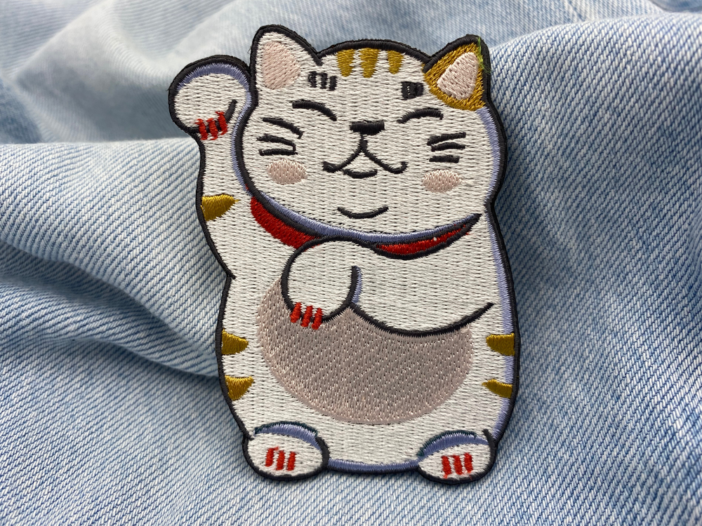 Glückskatzen Patch auf blauer Jeans