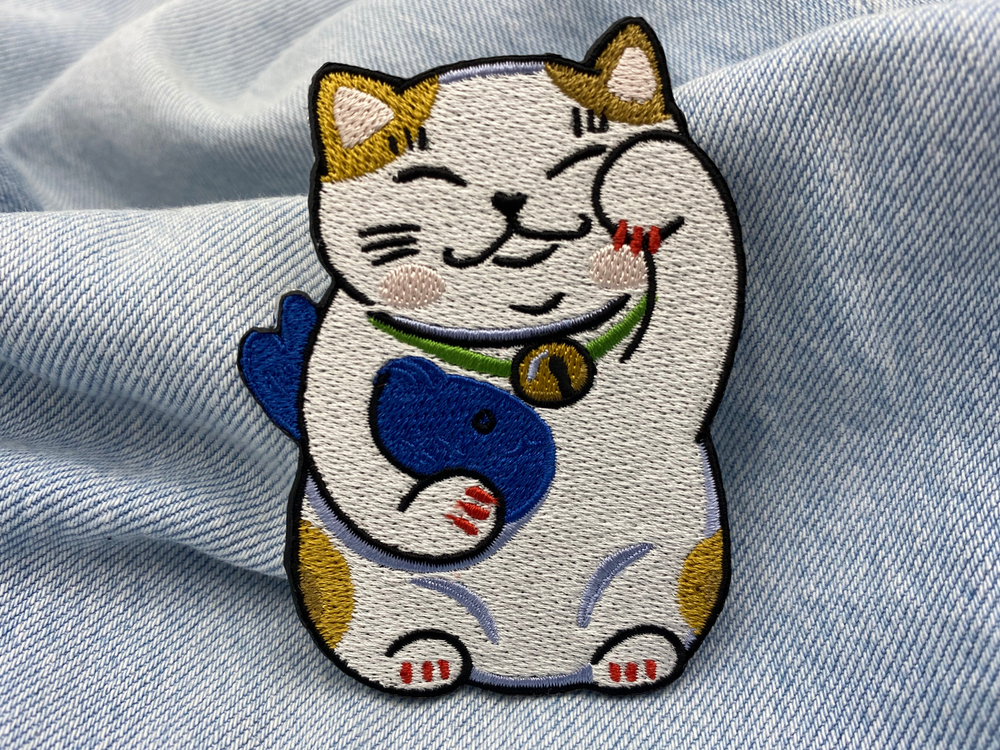 Glückskatze Patch auf blauer Jeans