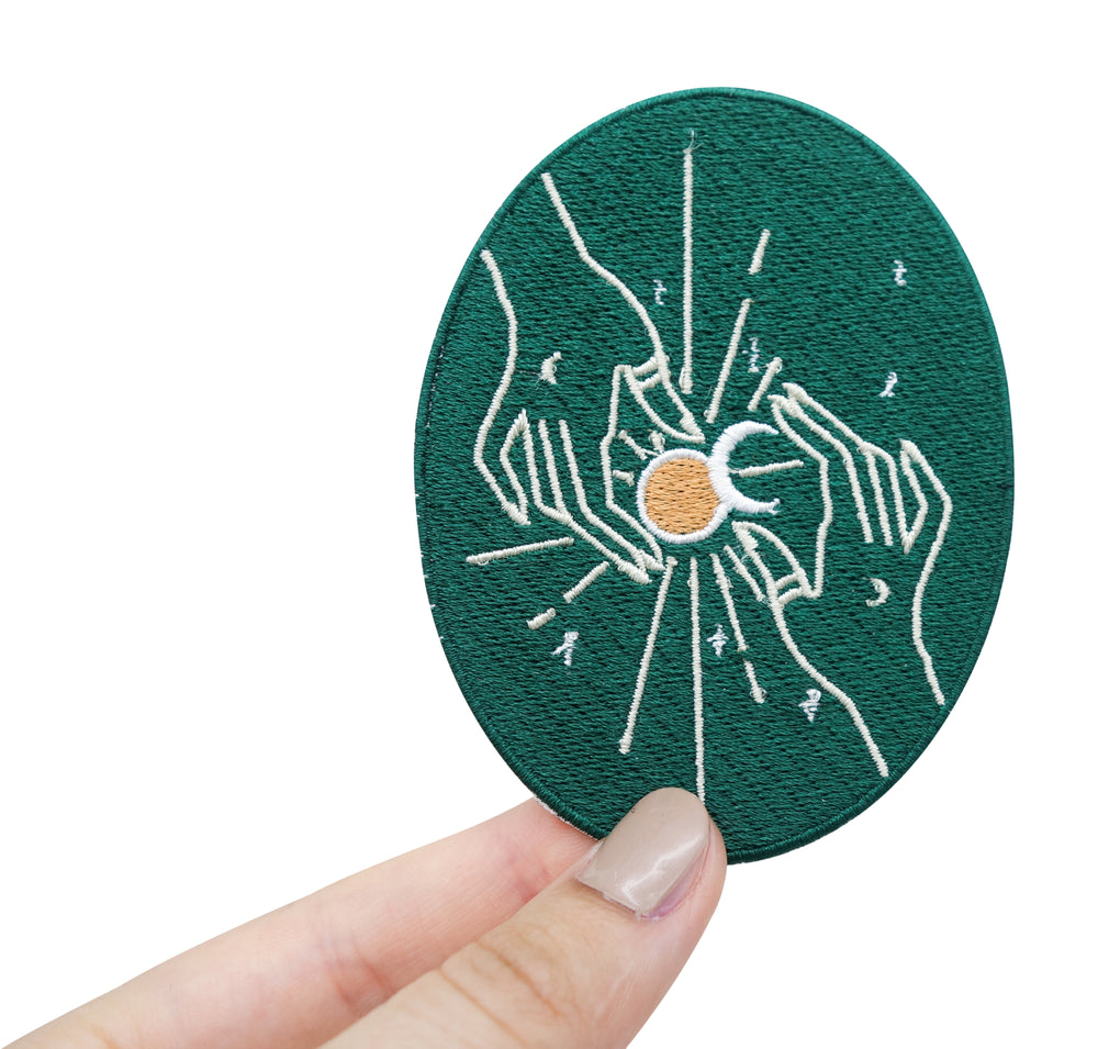Frauenhand hält den Mondfinsternis Patch