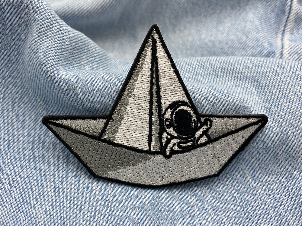 Astronauten-Patch auf blauer Jeans für stylischen Weltraum-Look.
