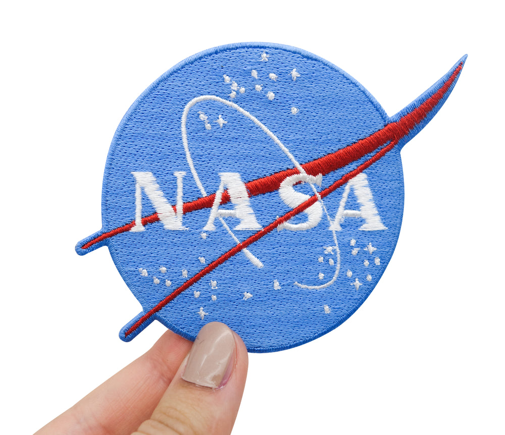 Hand hält den blauen NASA Logo Patch