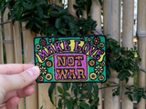 Make Love Patch vor einem Bambuszaun gehalten von einer Frauenhand