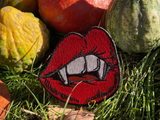 Vampir Kussmund Patch mit Kürbissen im Hintergrund