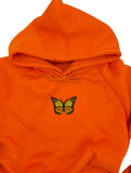 Oranger Schmetterling Patch auf orangenem Pullover aufgebügelt