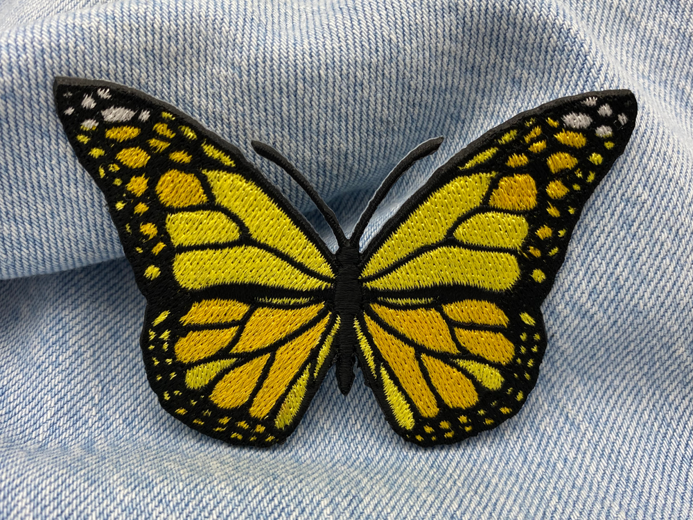 Gelber Schmetterling Patch auf blauer Jeans
