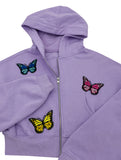 Drei Schmetterling Patches auf lila Pullover aufgebügelt