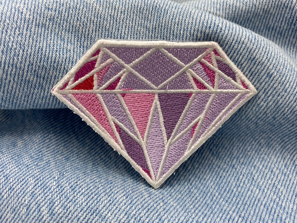 Rosa Diamant Patch auf blauer Jeans.