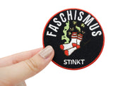 Faschismus stinkt Patch gehalten von einer Frauenhand
