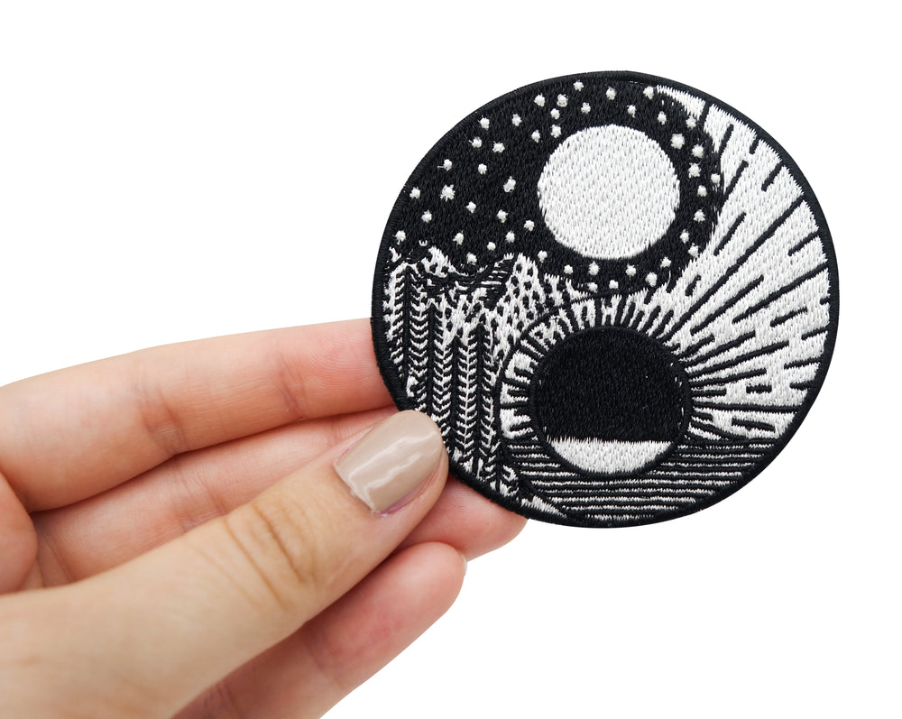 Frauenhand hält den Yin und Yang Patch