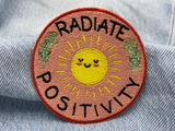 "Radiate Positivity" Patch auf blauer Jeans
