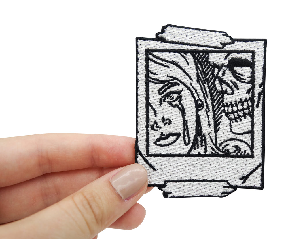 Frauenhand hält Totenkopf Selfie Patch