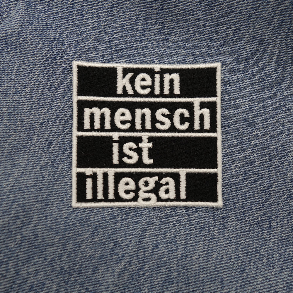 Statement Patch auf dunkel blauer Jeans aufgebügelt
