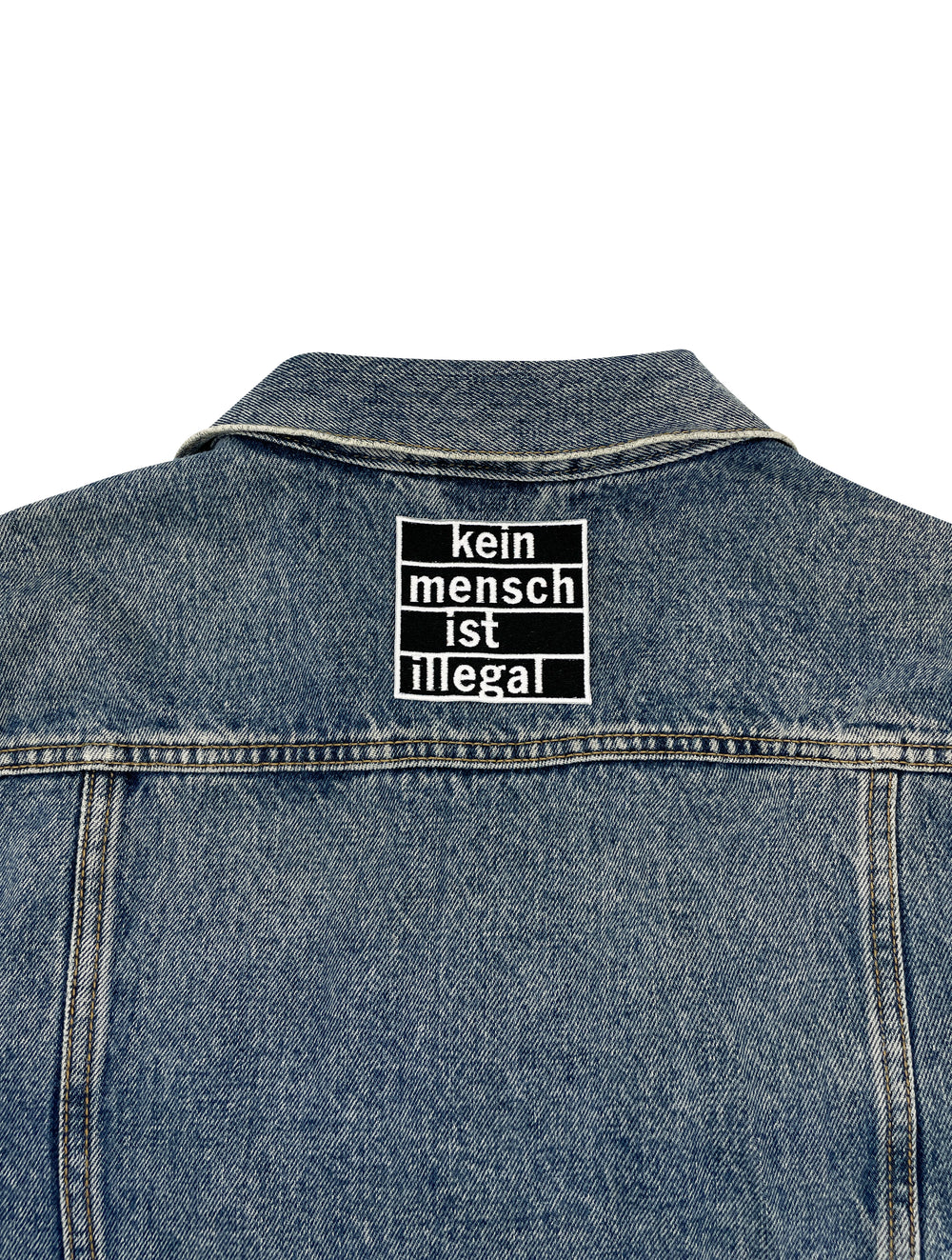 Statement Patch auf Rückseite einer Jeansjacke aufgebügelt