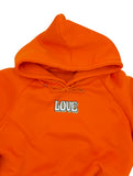 Love Patch auf orangenem Pullover