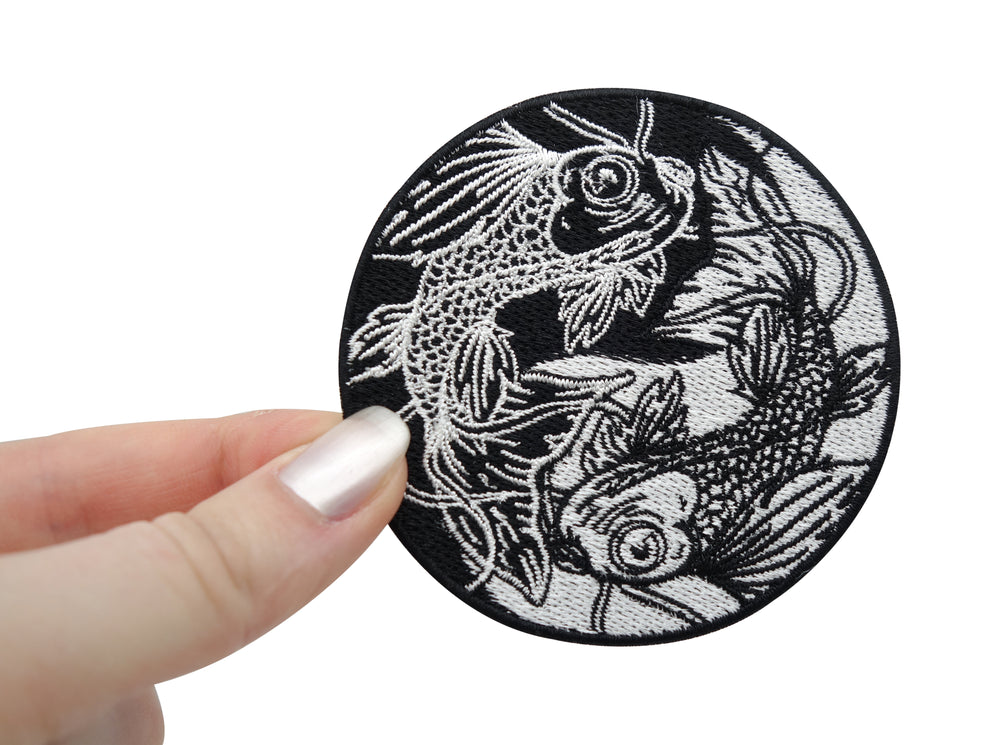 Frauenhand hält den Yin und Yang Patch