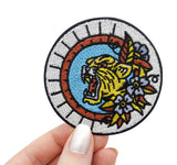 Frauenhand hält den Tiger Patch