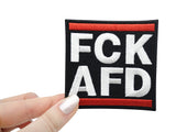 Frauenhand hält den FCK AFD Patch
