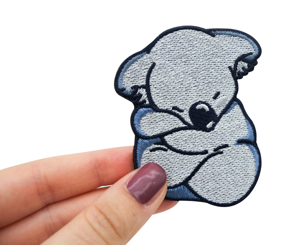 Frauenhand hält den Koala Patch