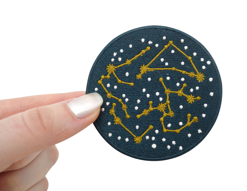 Frauenhand hält den Sternenbilder Patch