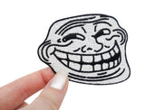 Trollface Meme Patch gehalten von einer Frauenhand