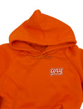 Cozy Patch auf orangenem Pullover aufgebügelt