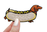 Frauenhand hält den Dackel Hot Dog Patch