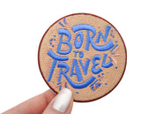 Frauenhand hält den Born to Travel Patch