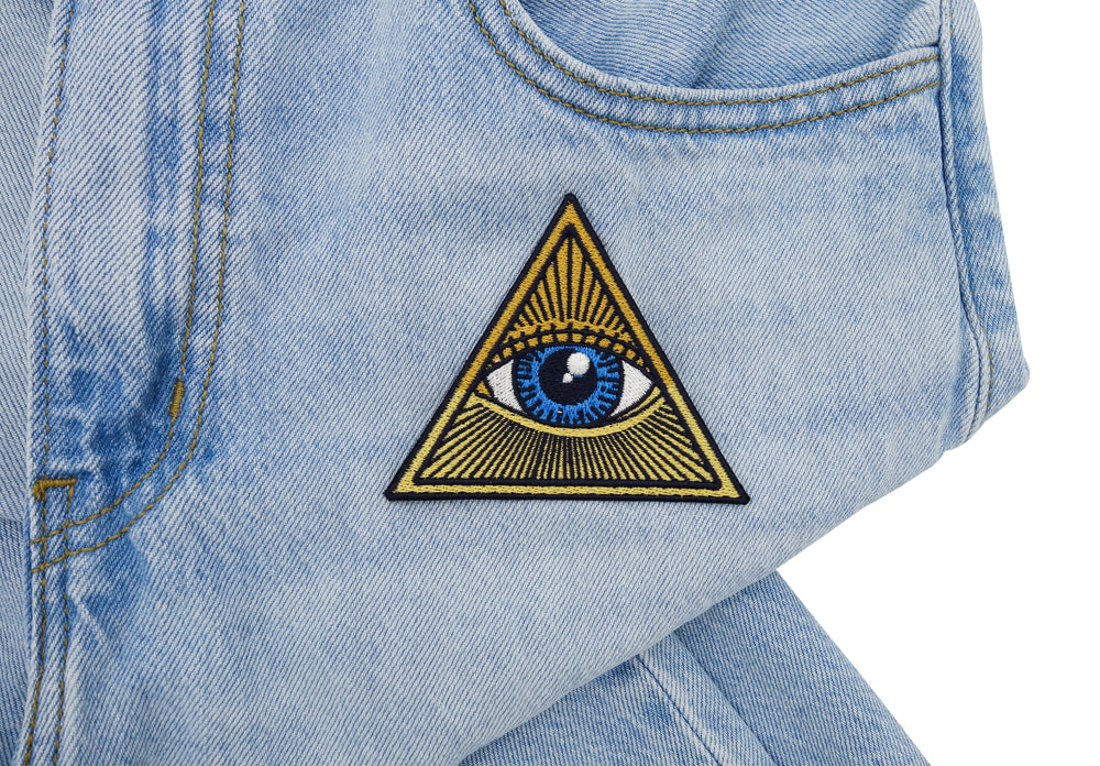 Illuminati Patch auf heller blauer Jeans aufgebügelt