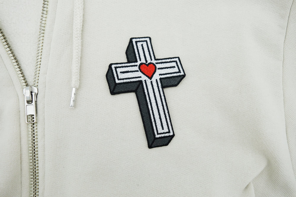 Kreuz Patch auf weißer Jacke aufgebügelt