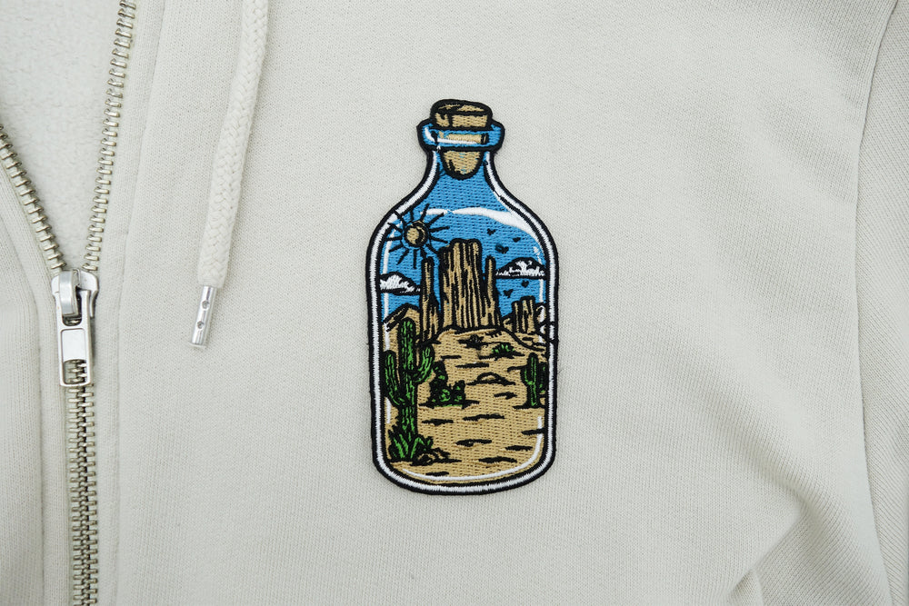 Wüste in der Flasche Patch auf weißer Strickjacke aufgebügelt