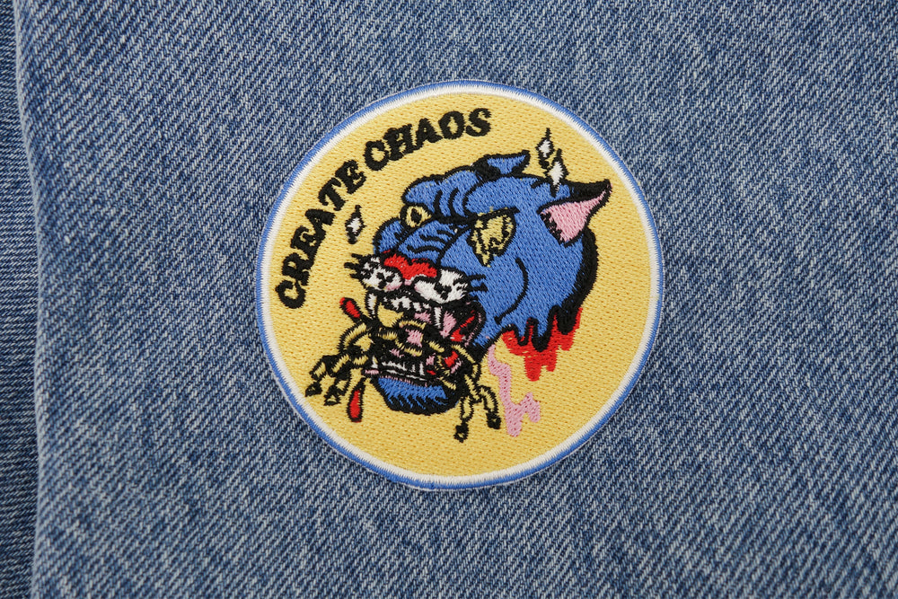 Chaos Patch auf blauer Jeans