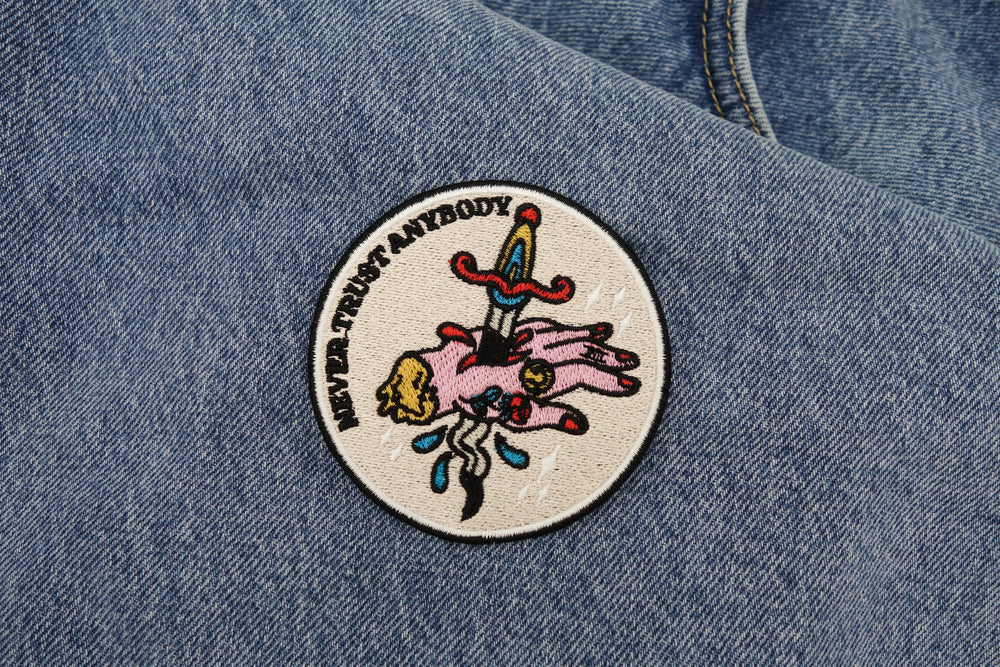 Never Trust Anybody Patch auf blauer Jeans Patch
