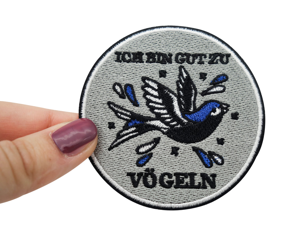 Frauenhand hält den Vogel Patch