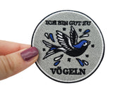 Frauenhand hält den Vogel Patch