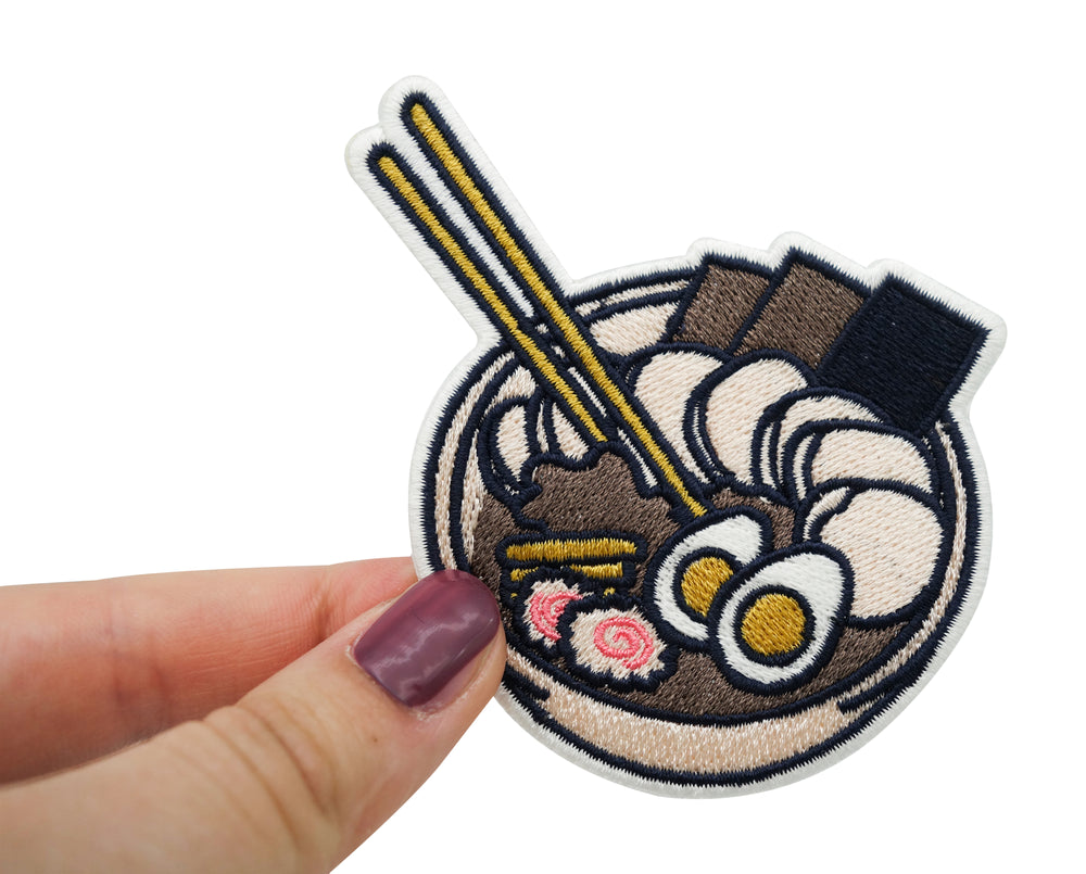 Frauenhand hält den Ramen Bowl Patch
