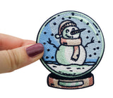 Frauenhand hält den Schneemann Patch