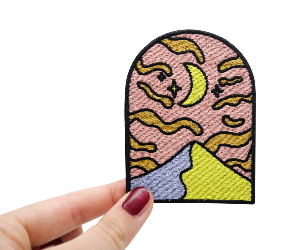 Mond in den Bergen Patch gehalten von einer Frauenhand