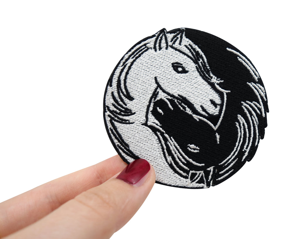 Frauenhand hält den Pferdeköpfe Patch