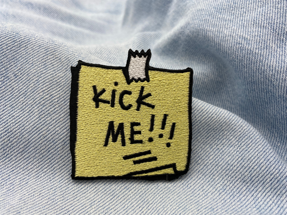 Kick Me Patch auf hellblauer Jeans
