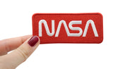 Frauenhand hält den NASA Patch