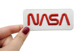 Frauenhand hält den weißen NASA Patch