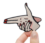 Fingerpistole Patch gehalten von einer Frauenhand