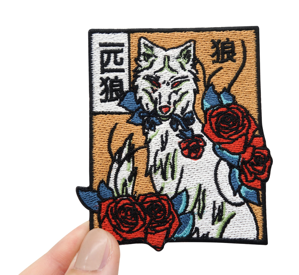 Frauenhand hält den Wolf mit Rosen Patch