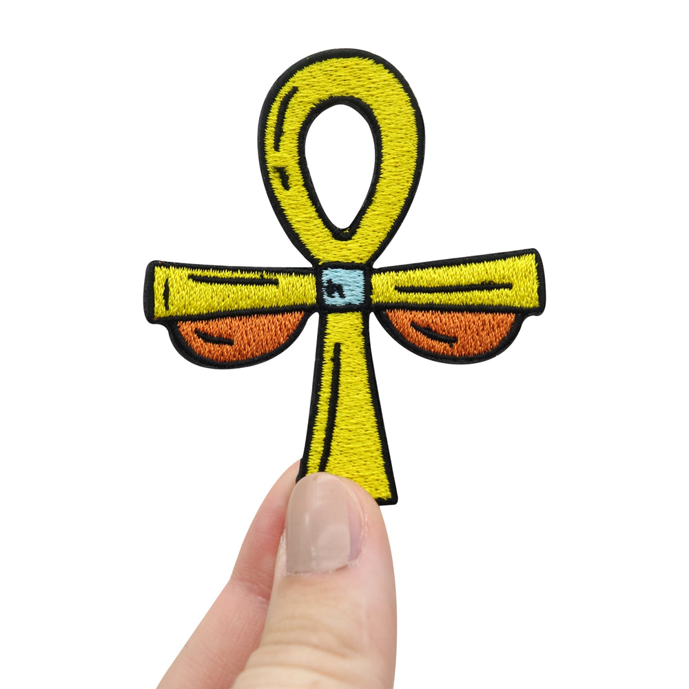 Frauenhand hält den Kreuz Patch