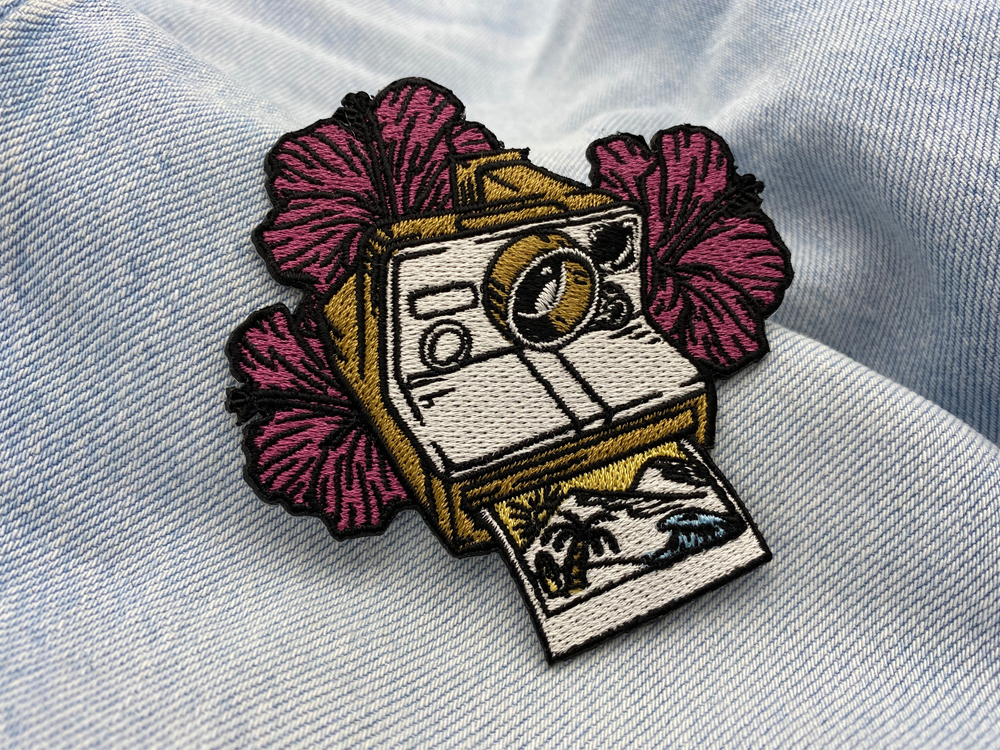 Polaroid Kamera Patch auf hellblauer Jeans