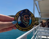 Seemann Patch gehalten von einer Frauenhand mit dem Meer im Hintergrund