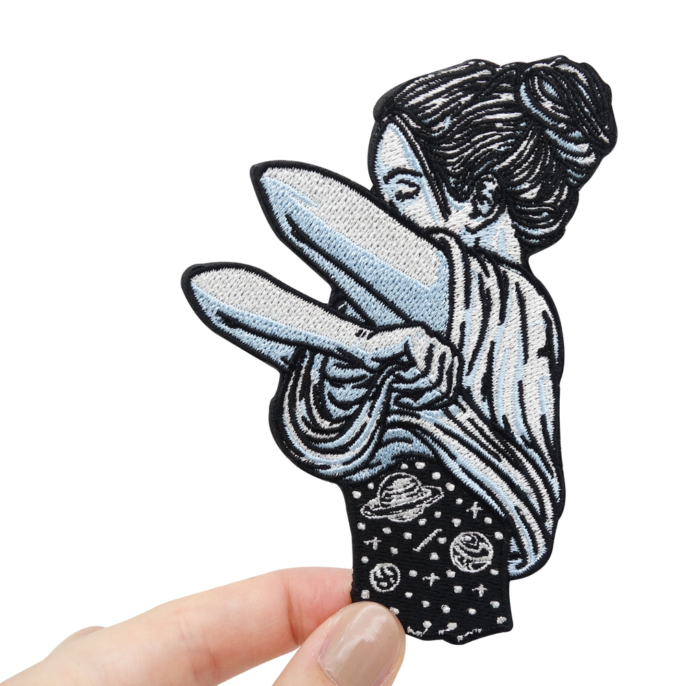 Frauenhand hält den Frau mit Weltraumkörper Patch