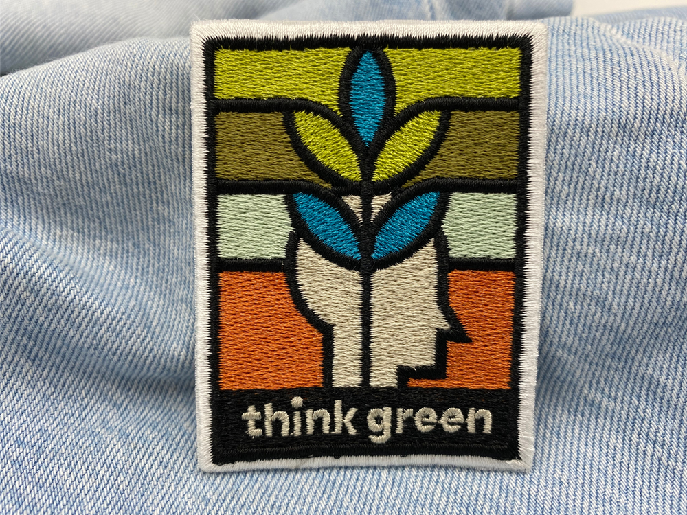 Think Green Patch auf hellblauer Jeans